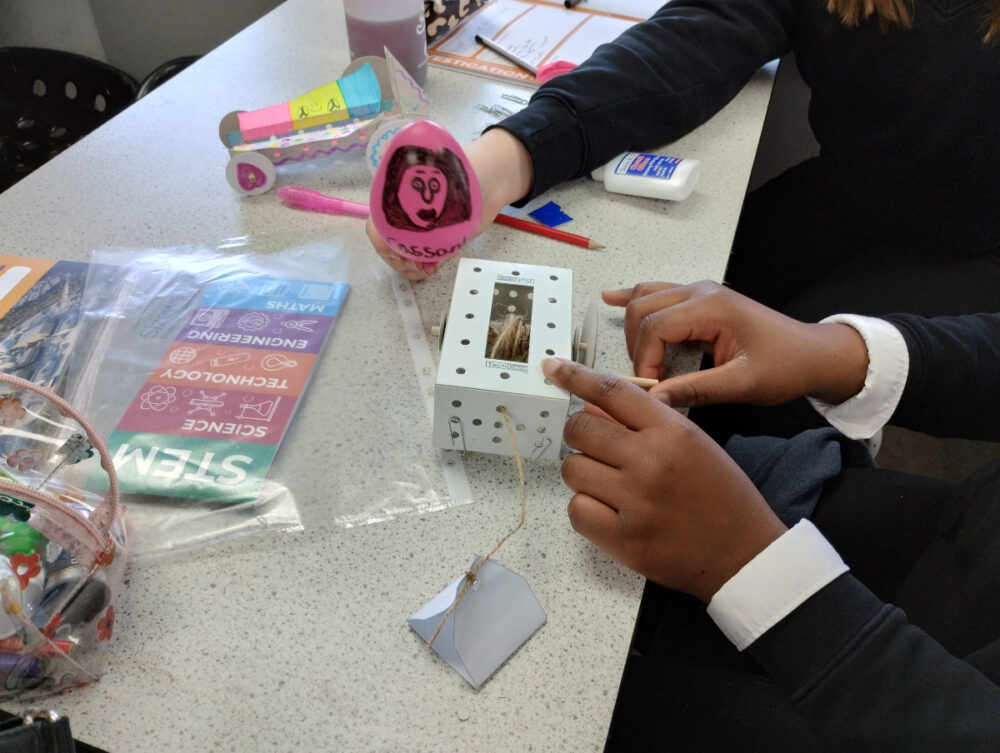 Students building a miniature car powered by a balloon